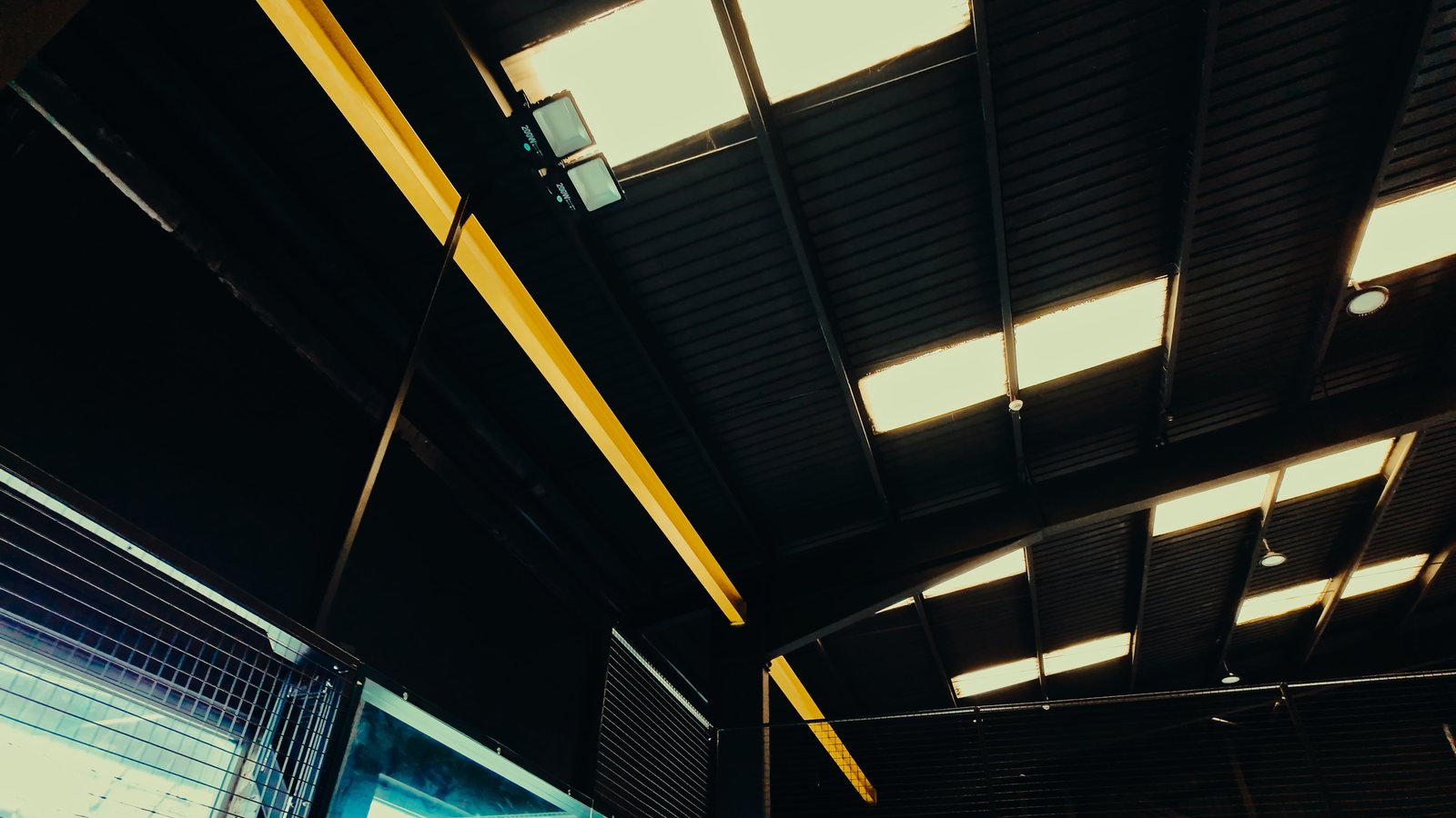 The steel roof structure and lighting above an indoor padel facility